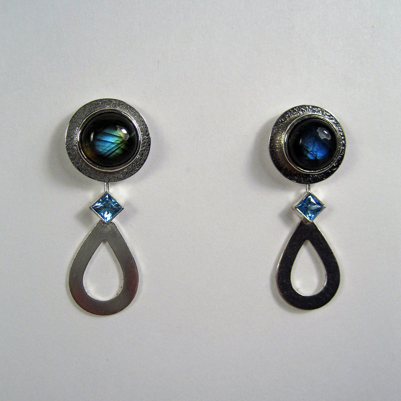 The sea of tears round ear studs and dropshaped ear jackets Alice in wonderland exclusive collection sterling silver earrings cabochon labradorite with princess cut topaz unique piece € 185,- Daphne Meesters Jewellery Designer Goldsmith The Hague Netherlands