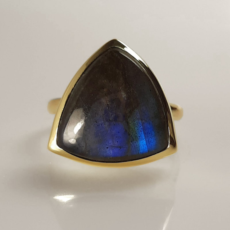 Trilliant memorial ring ashes jewellery from inherited 14K yellow gold with trilliant cut labradorite grey black with blue shine filled underneath with ashes of a deseased Daphne Meesters Jewellery Designer Goldsmith The Hague Netherlands