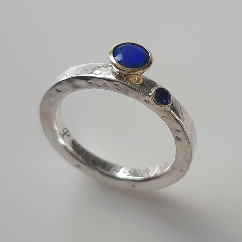 'Craters' ring with hammered moon craters surface from sterling silver and inherited 14 carat yellow gold bowls with blue green opal and dark blue sapphire  Daphne Meesters Jewellery Designer Goldsmith The Hague Netherlands