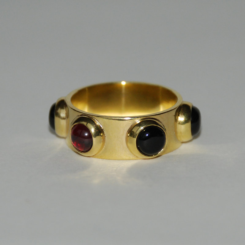 Russian roulette ring From Russia with love collection sterling silver 5 black onyx cabochons and 1 red garnet cabochon 14K gold layer size 17 or 17.5 millimeters € 236,50 per piece Daphne Meesters Jewellery Designer Goldsmith The Hague Netherlands