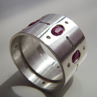 Ring sterling silver and oval faceted cut rubies lines dots contemporary wide band Daphne Meesters Jewellery  Designer Goldsmith The Hague Netherlands
