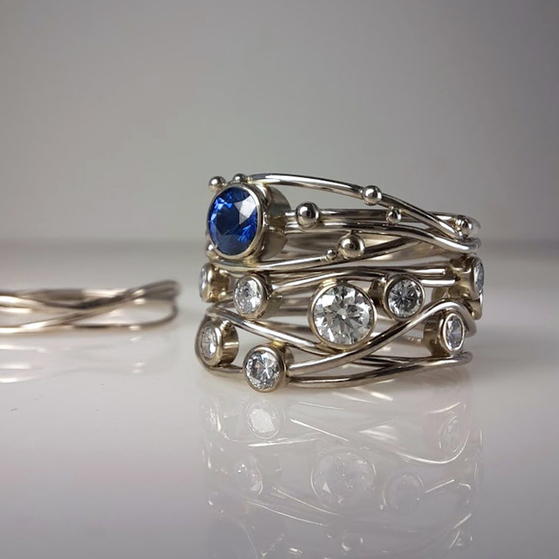 Birds nest engagement ring and wedding rings from 14 carat white gold wire and balls with sapphire and precious inherited diamonds in between  Daphne Meesters Jewellery Designer Goldsmith The Hague Netherlands
